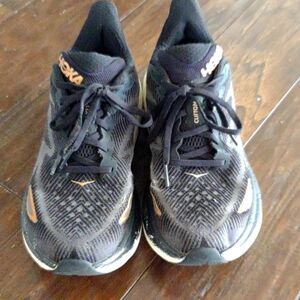 HOKA Clifton 9 black lace up athletic shoes with bronze accents